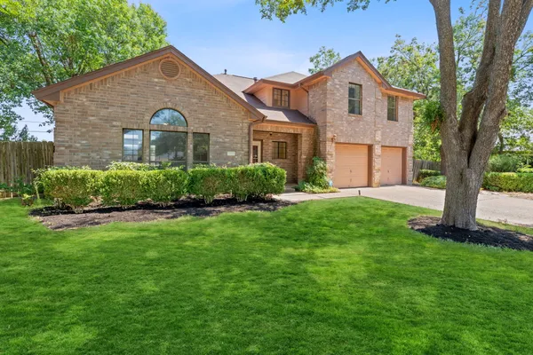a front view of a house with a yard and trees