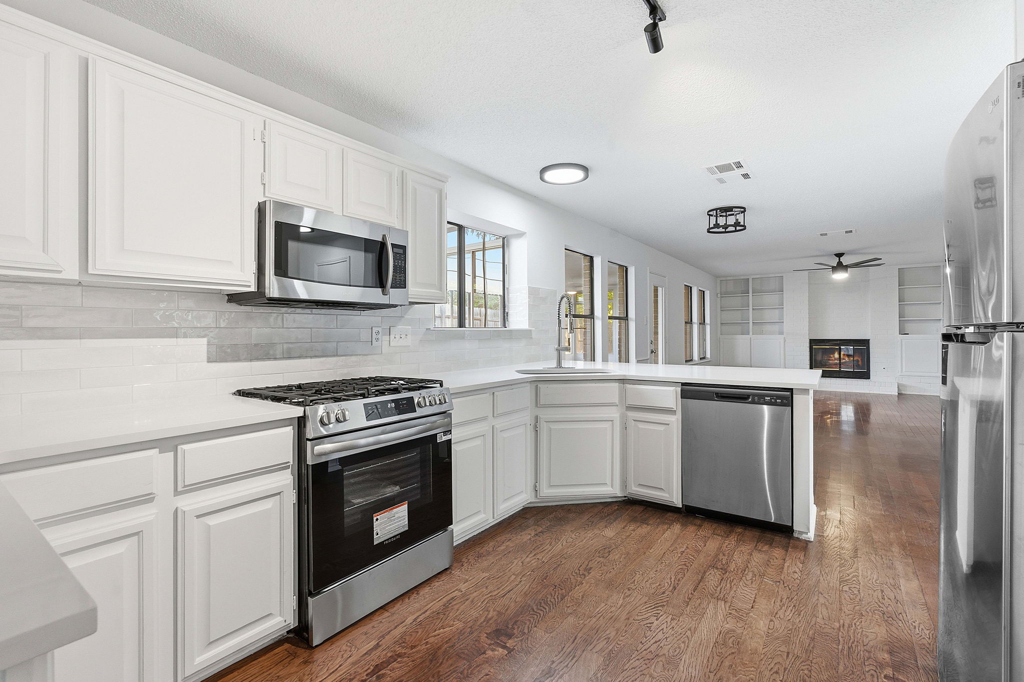 1106 Split Oak Cove Pflugerville, TX 78660 - Photo 4 of 27 a kitchen with granite countertop white cabinets and stainless steel appliances