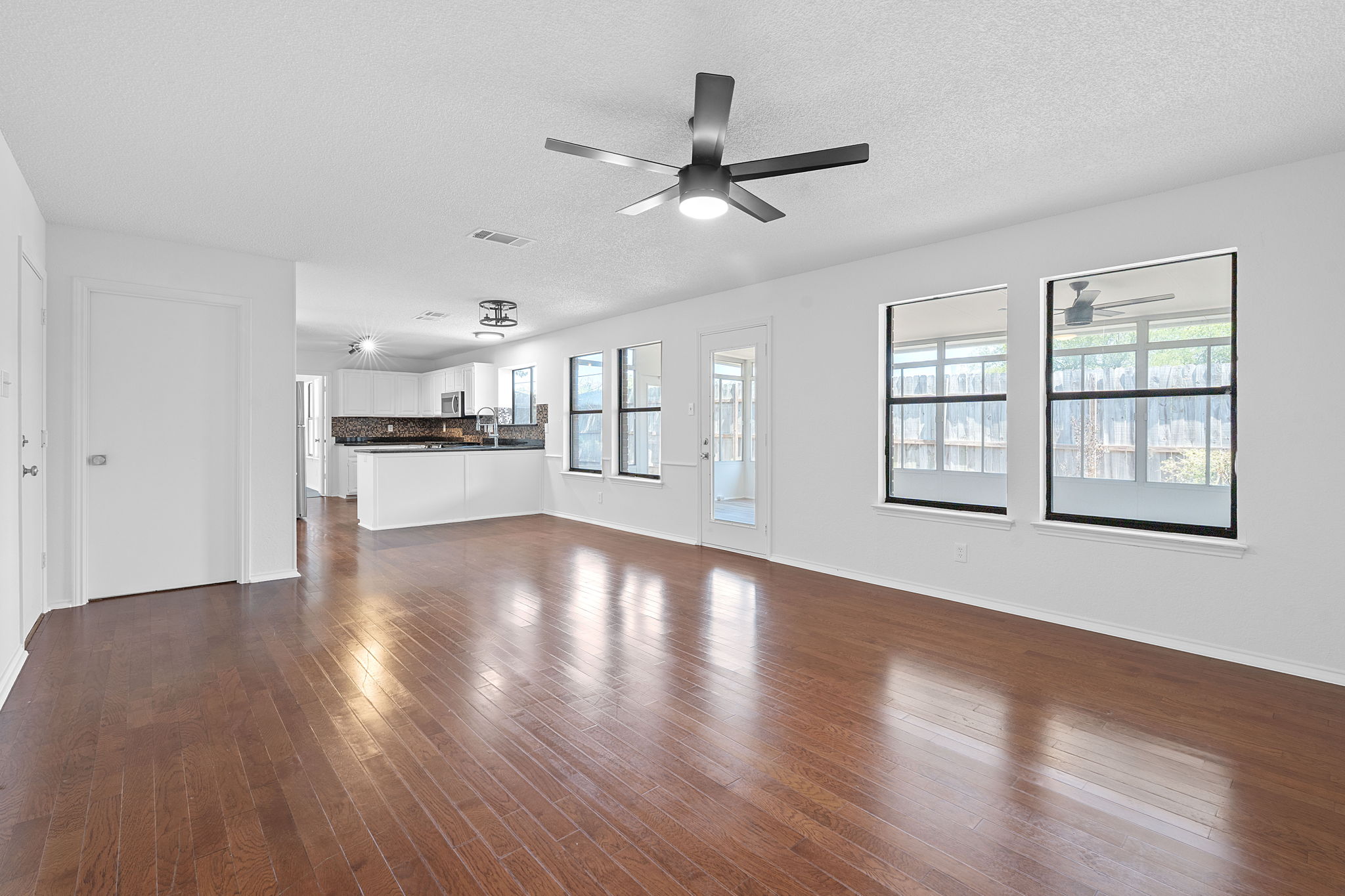 1106 Split Oak Cove Pflugerville, TX 78660 - Photo 8 of 27 a view of an empty room with wooden floor and a window