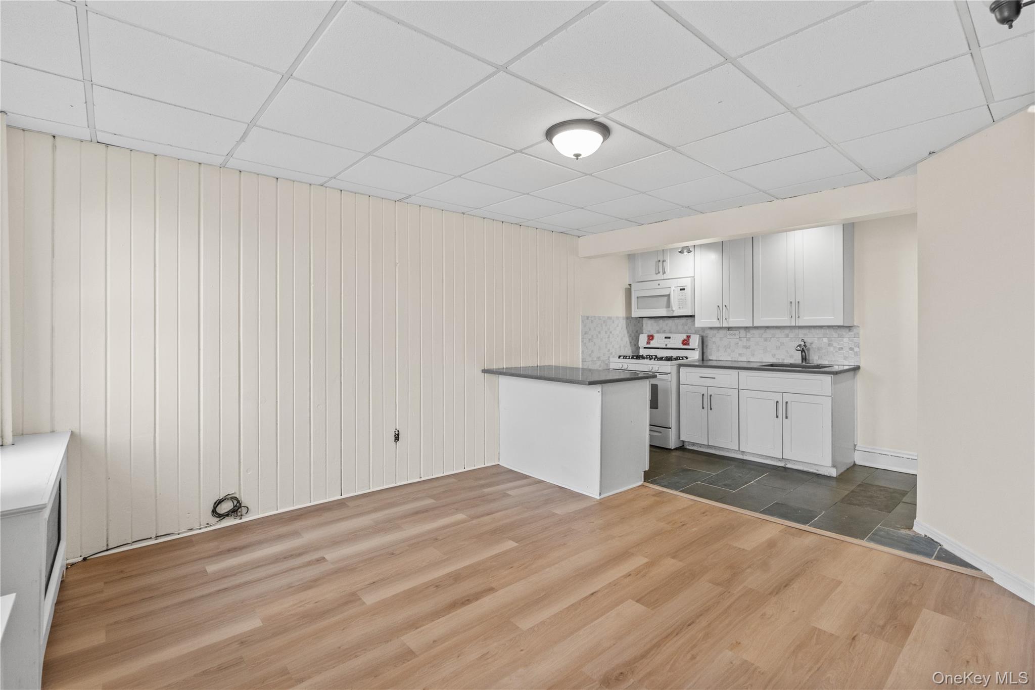 947 Diven Street Peekskill, NY 10566 - Photo 19 of 28 a kitchen with white cabinets and wooden floor