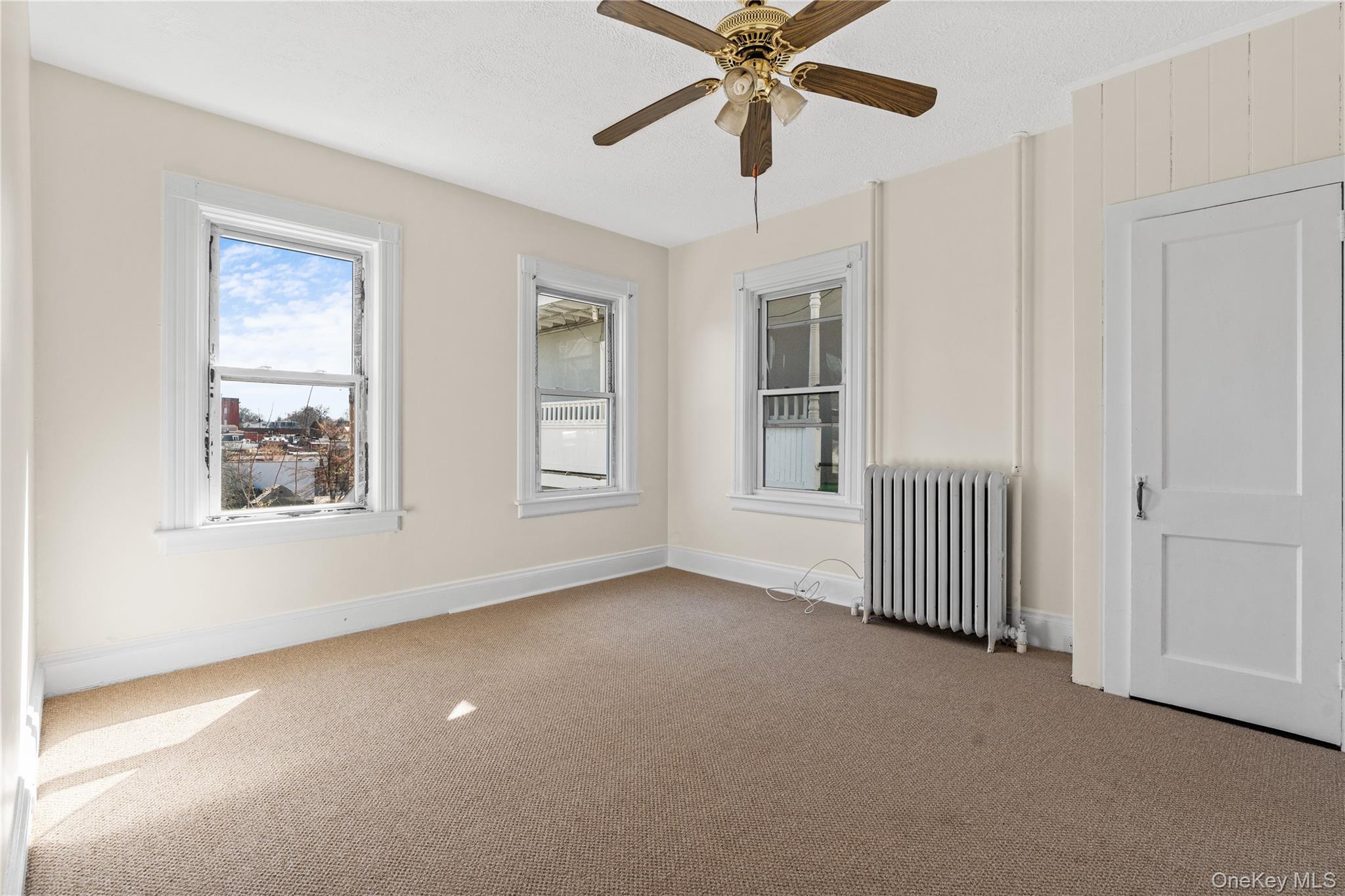 947 Diven Street Peekskill, NY 10566 - Photo 5 of 28 an empty room with windows and fan