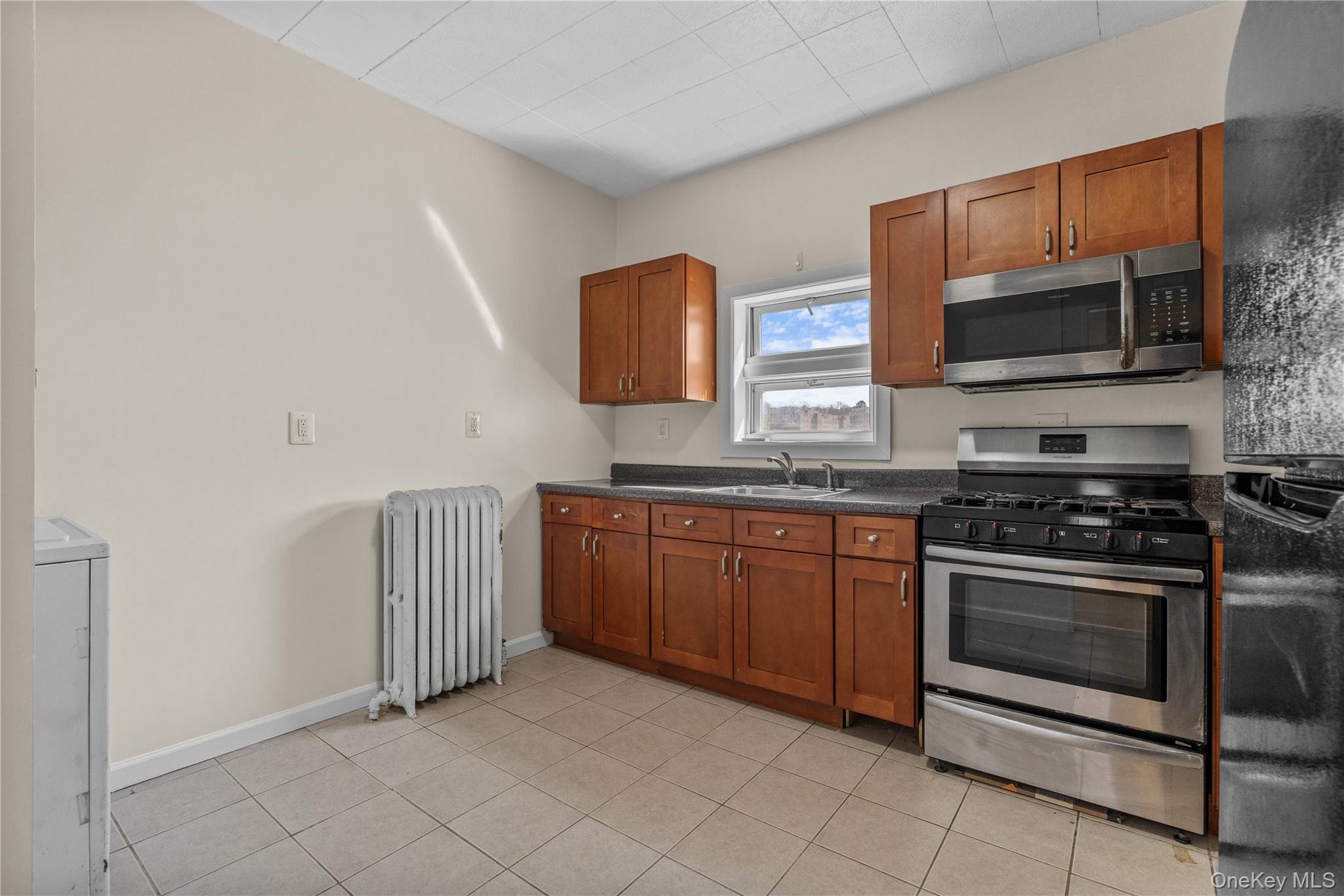 947 Diven Street Peekskill, NY 10566 - Photo 9 of 28 a kitchen with stainless steel appliances granite countertop a stove microwave and sink