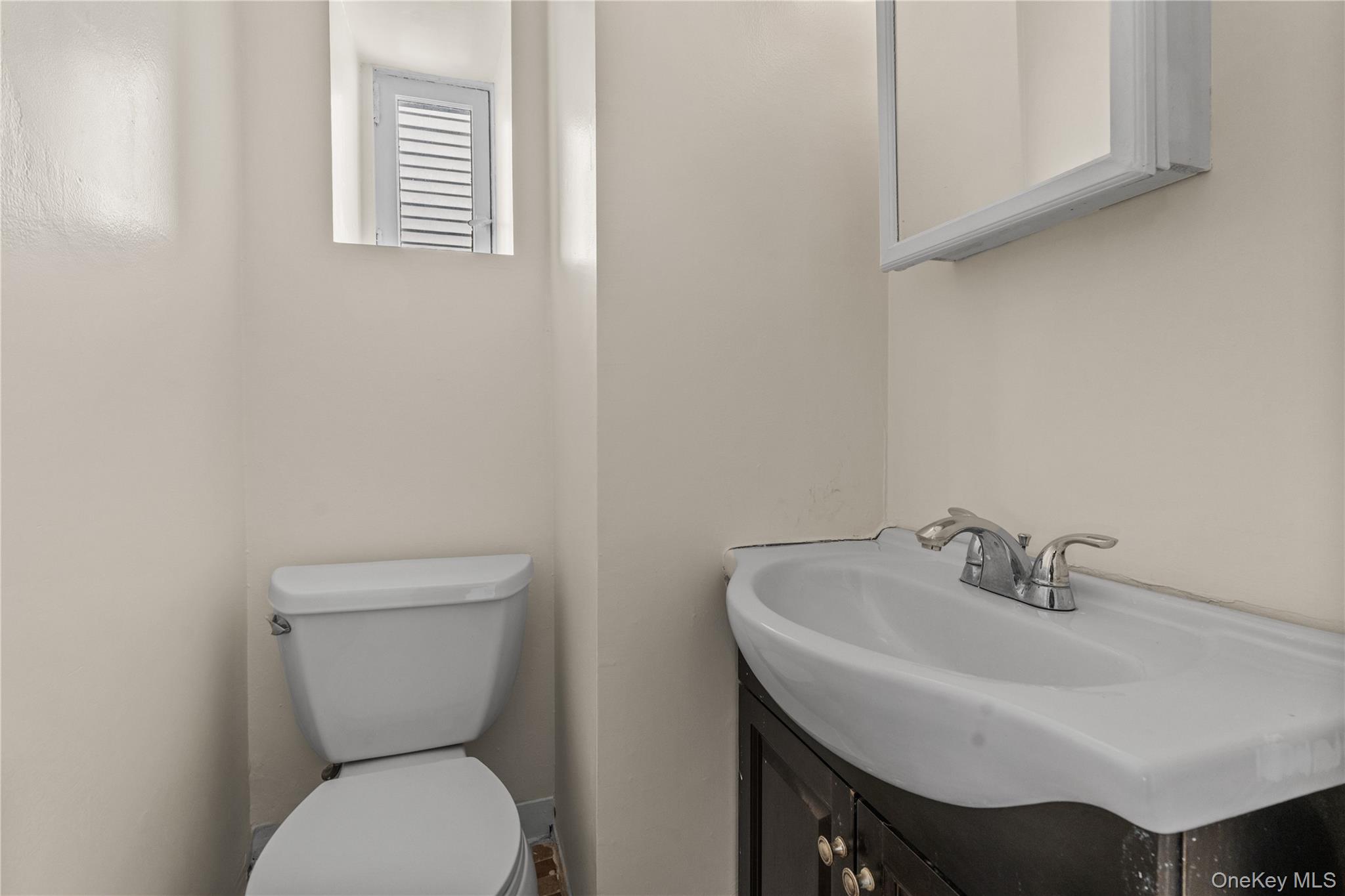 947 Diven Street Peekskill, NY 10566 - Photo 10 of 28 a bathroom with a toilet sink and mirror