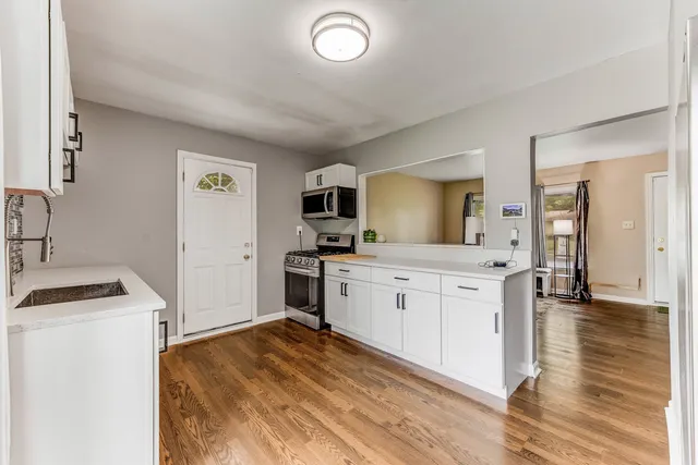 a kitchen with granite countertop a sink stove and refrigerator
