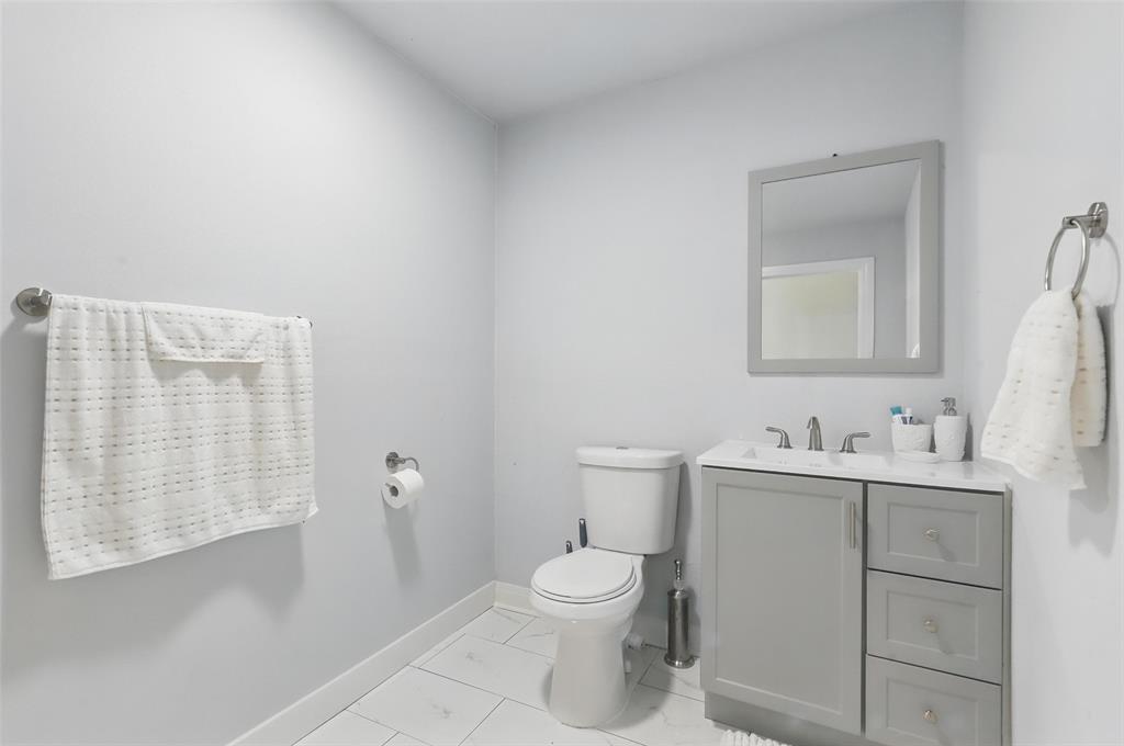 5200 Barbara Road River Oaks, TX 76114 - Photo 17 of 40 a bathroom with a toilet a sink and mirror