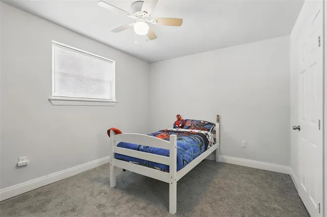 a bedroom with a bed and a chandelier fan