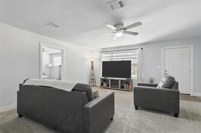 a living room with furniture and a ceiling fan