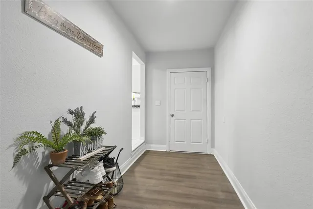 a view of a room with wooden floor and a potted plant