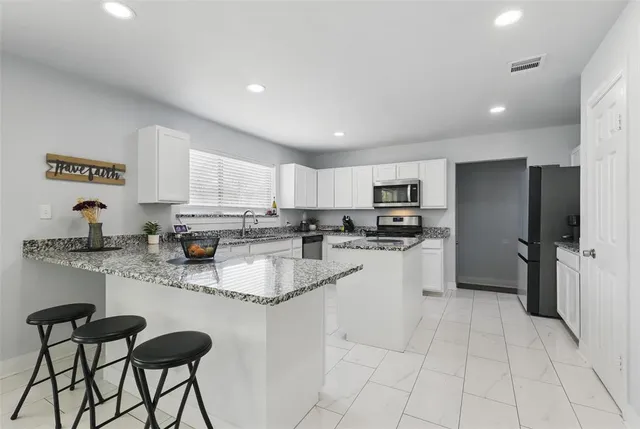 a kitchen with stainless steel appliances granite countertop a refrigerator sink and cabinets