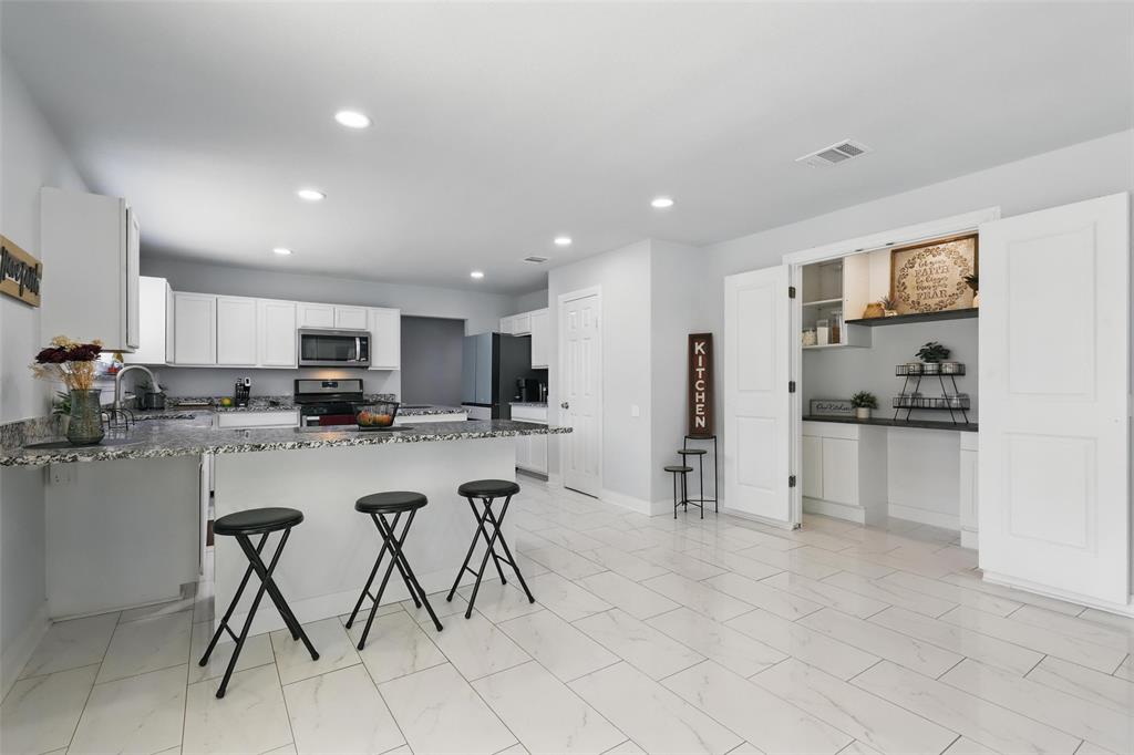 5200 Barbara Road River Oaks, TX 76114 - Photo 7 of 40 a kitchen with stainless steel appliances kitchen island granite countertop a refrigerator and cabinets