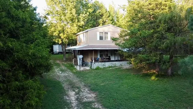 a view of a house with backyard and a tree