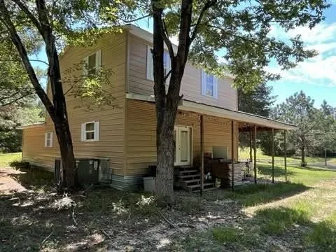 a front view of house with yard and trees