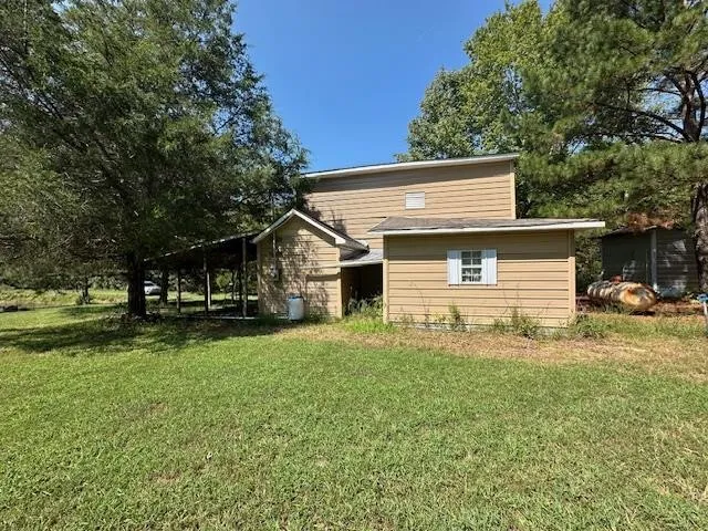 an aerial view of a residential houses with outdoor space and trees