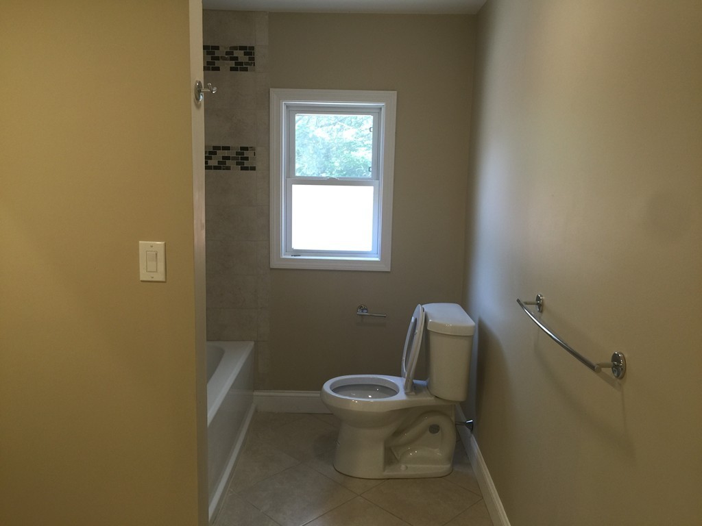 28 Bulfinch Terrace Lynn, MA 01902 - Photo 13 of 30 a white toilet sitting in a bathroom next to a window
