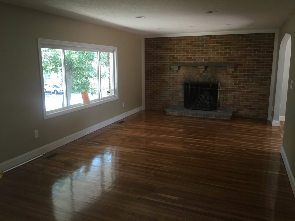 28 Bulfinch Terrace Lynn, MA 01902 - Photo 6 of 30 an empty room with wooden floor fireplace and windows
