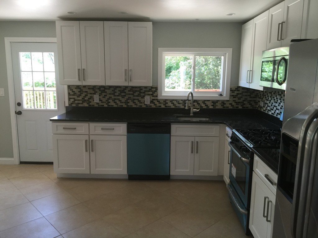 28 Bulfinch Terrace Lynn, MA 01902 - Photo 9 of 30 a kitchen with granite countertop a stove sink and cabinets