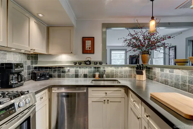a kitchen with stainless steel appliances granite countertop a sink a stove and a wooden cabinets
