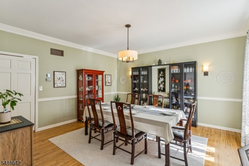 11 North Ridge Road Denville, NJ 07834 - Photo 9 of 43 a dining room with furniture wooden floor a potted plant and chandelier