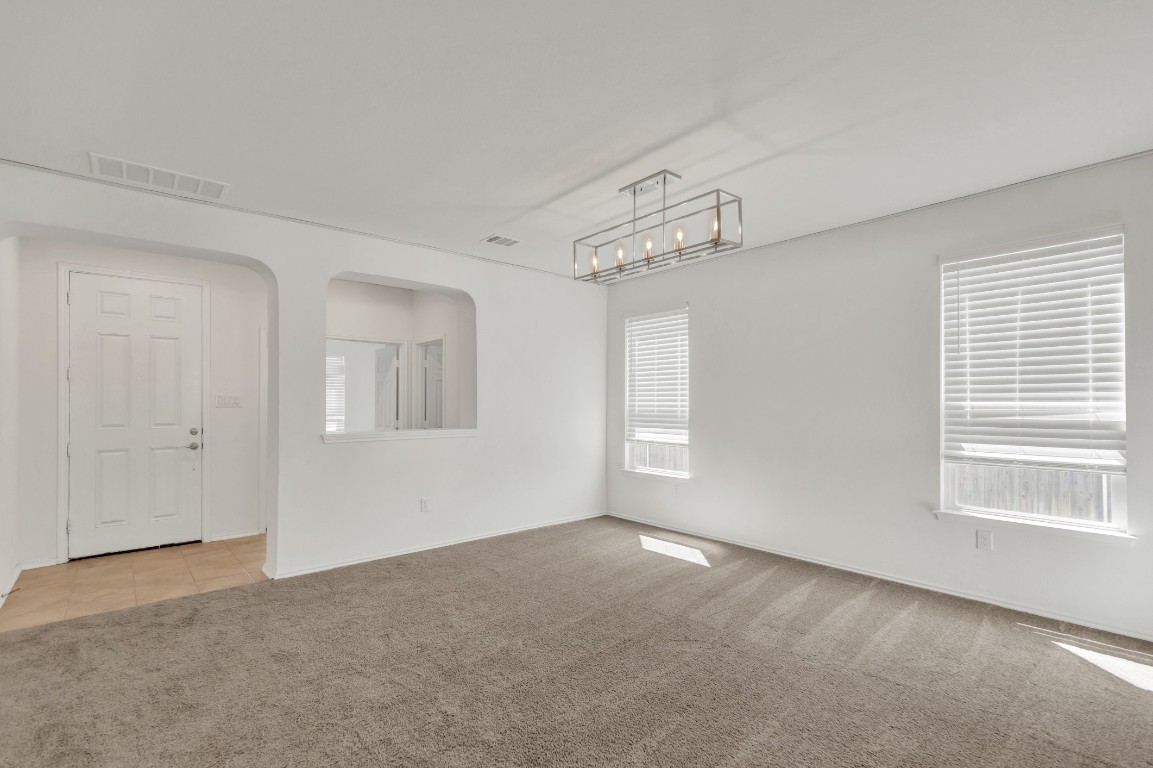 195 Azure Cove Kyle, TX 78640 - Photo 11 of 32 Empty room with light colored carpet and arched walkways