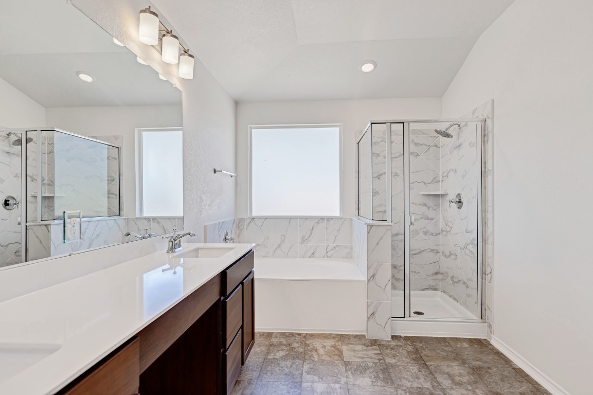 195 Azure Cove Kyle, TX 78640 - Photo 22 of 32 Full bathroom with a garden tub, double vanity, and a marble finish shower