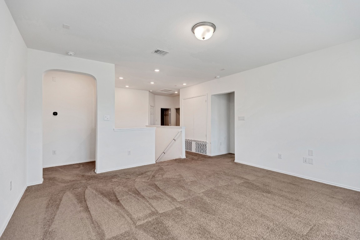 195 Azure Cove Kyle, TX 78640 - Photo 6 of 32 Carpeted empty room featuring arched walkways and recessed lighting