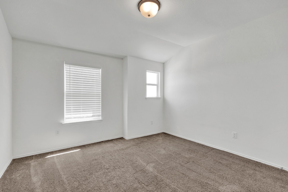 195 Azure Cove Kyle, TX 78640 - Photo 9 of 32 Carpeted spare room featuring vaulted ceiling and baseboards