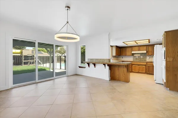 a view of empty room with wooden floor and ceiling fan