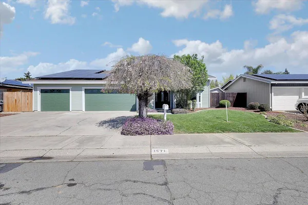 a front view of a house with a yard garage and outdoor seating