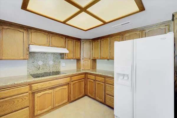 an empty room with a fan & a window