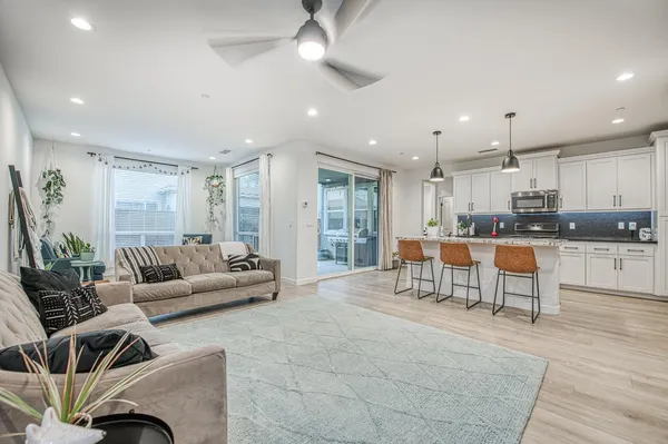 a kitchen with stainless steel appliances granite countertop a stove a sink a microwave a island with a dining table and chairs