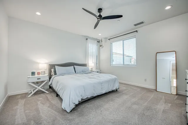 an aerial view of a city with lots of residential buildings and ocean view in back