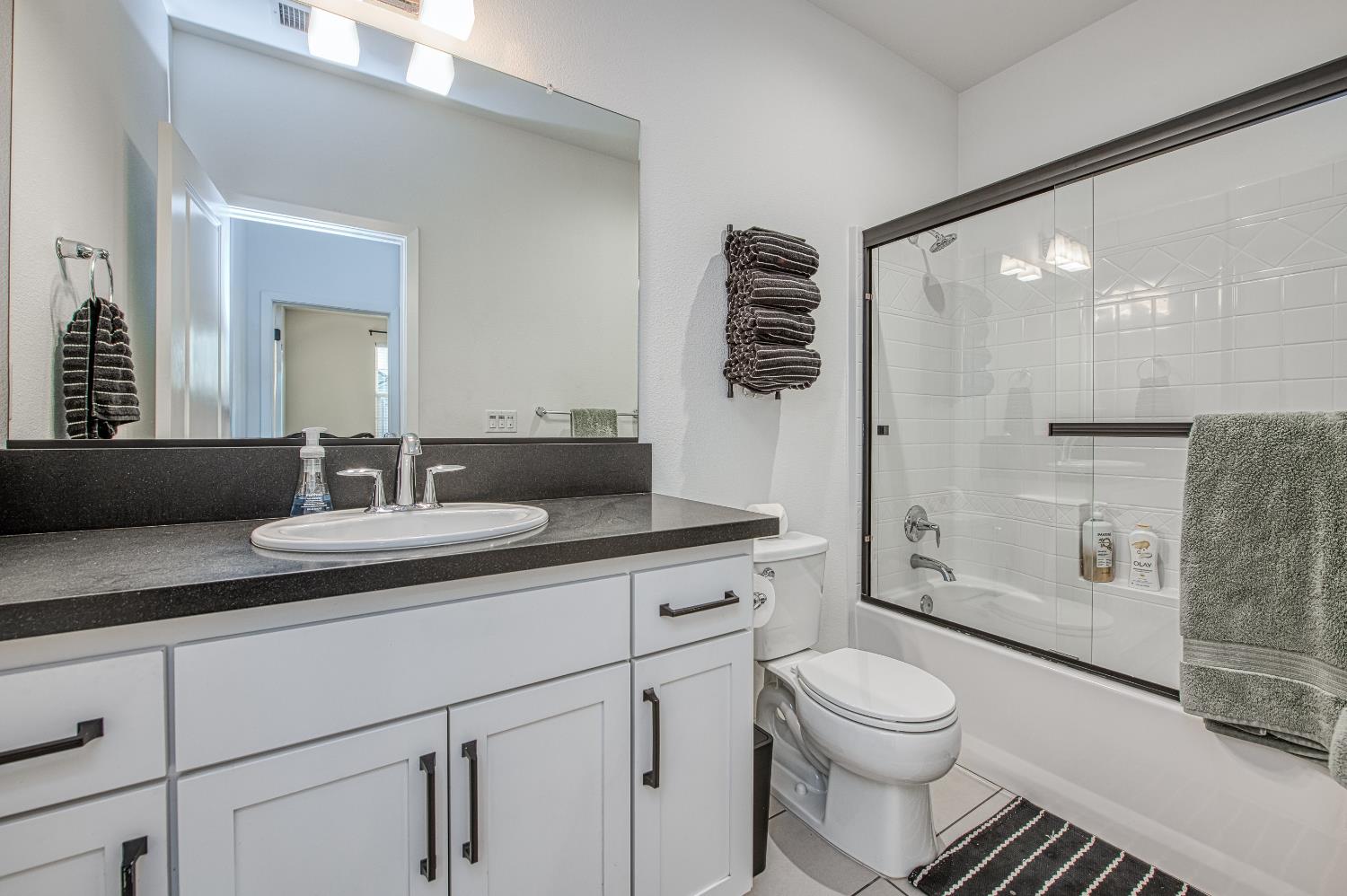 4311 San Miguel Road Madera, CA 93636 - Photo 42 of 79 a bathroom with a granite countertop sink a toilet a mirror and shower