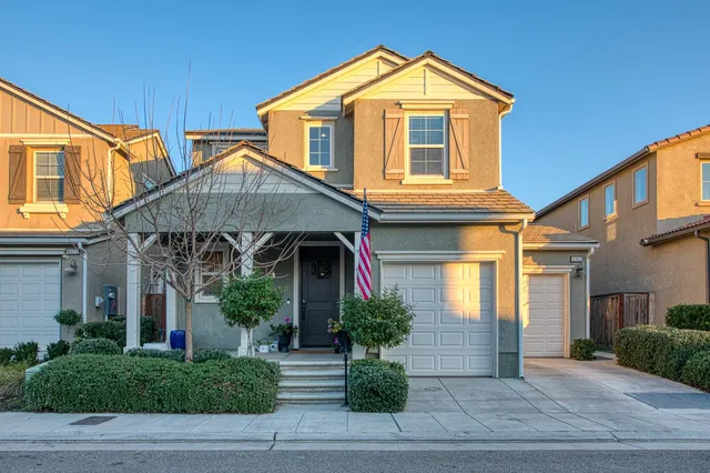 a kitchen with stainless steel appliances a stove a sink dishwasher a oven with a dining table and chairs with wooden floor