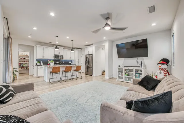 a kitchen with stainless steel appliances granite countertop a stove a refrigerator a oven a sink a island with a dining table and chairs