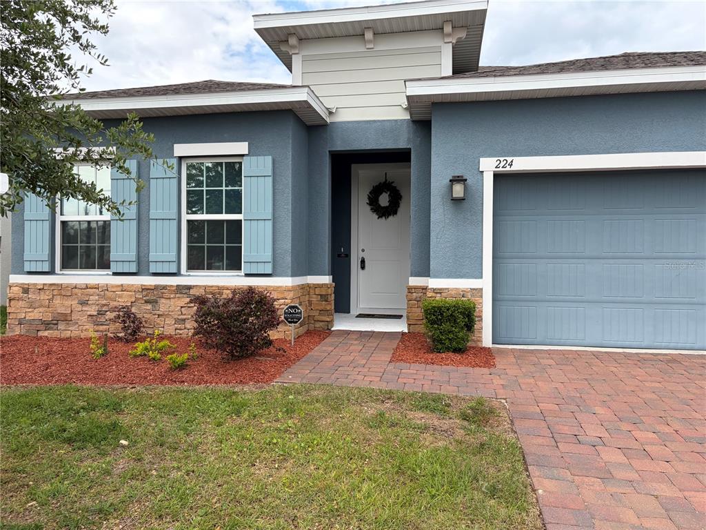 224 August Fern Loop Mount Dora, FL 32757 - Photo 3 of 27 a front view of a house with a yard