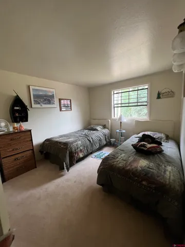 a bedroom with two bed and a window