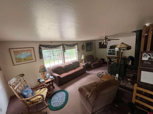 a living room with furniture a flat screen tv and a window