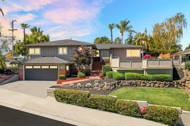 a front view of a house with a garden and a yard