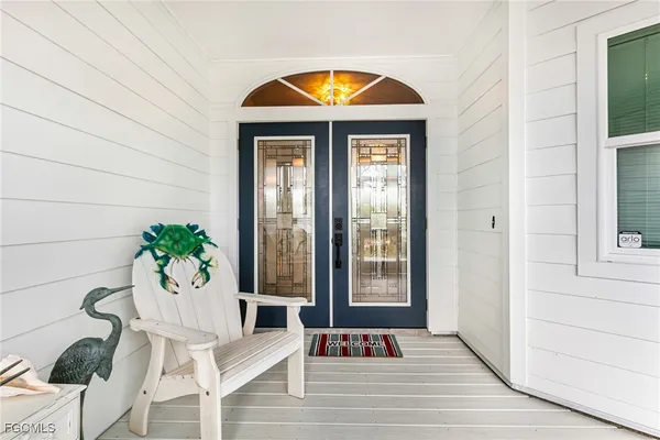 a kitchen with granite countertop a refrigerator and white cabinets