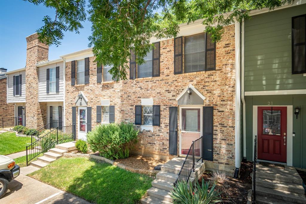 front view of a brick house with a small yard