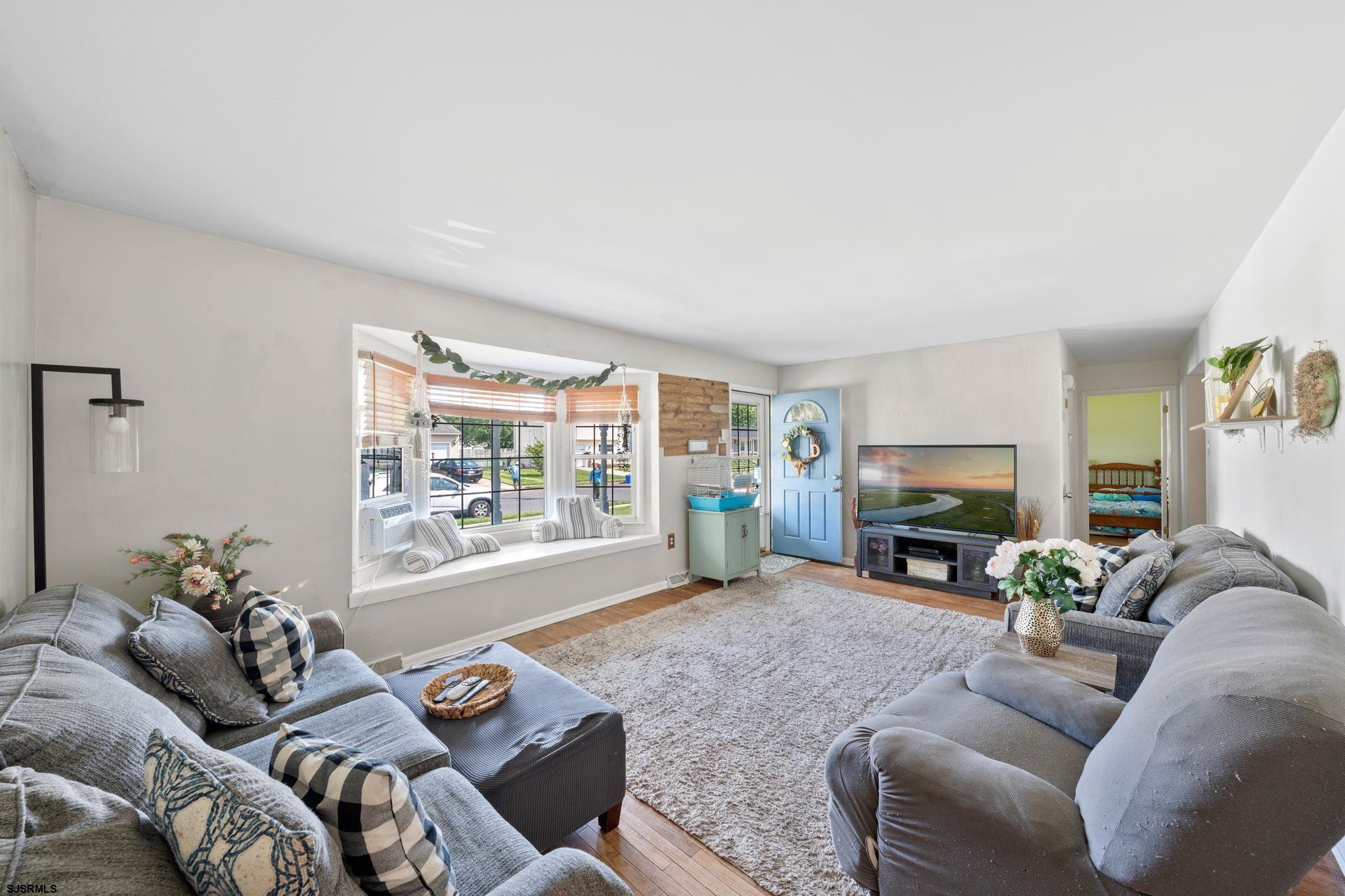 40 Gulph Mill Road Somers Point, NJ 08244 - Photo 3 of 21 a living room with furniture a fireplace and a floor to ceiling window