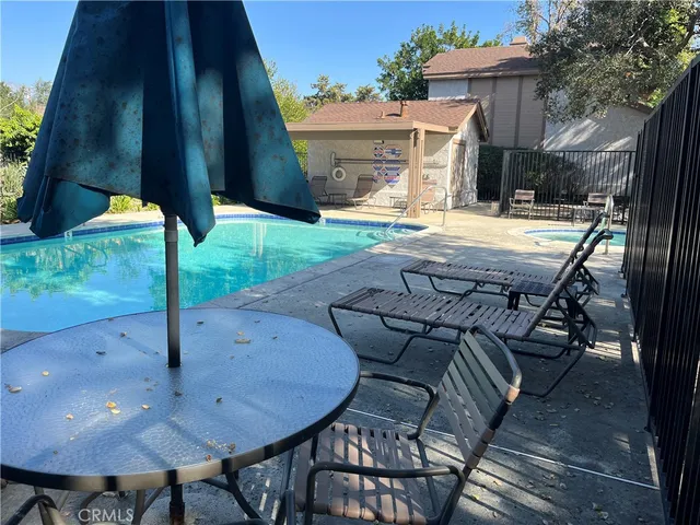 a view of a patio with table and chairs potted plants with wooden floor and fence