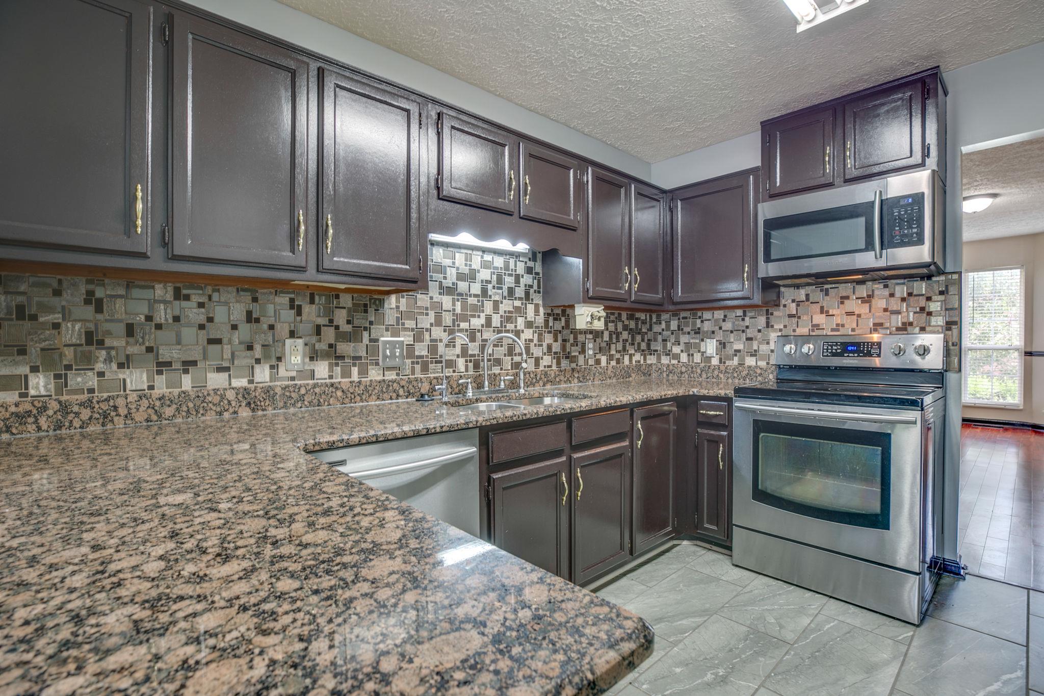 3429 Shakertown Road Antioch, TN 37013 - Photo 7 of 27 The Cozy Updated Kitchen Has New Granite Counters, Tiled Backsplash, Stainless Appliances and Plenty of Cabinet Space!