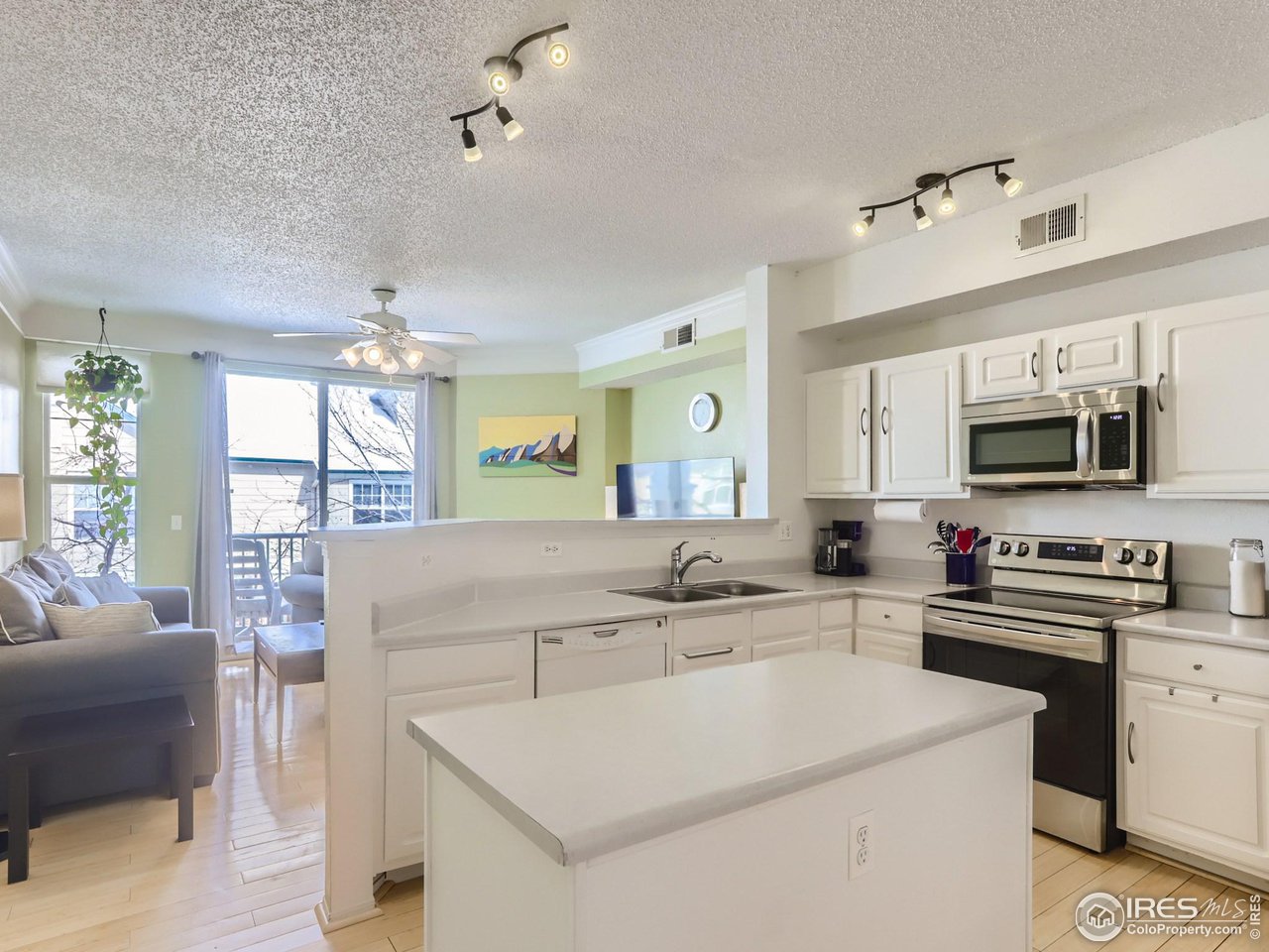 1855 Spaulding Circle Superior, CO 80027 - Photo 3 of 17 a large white kitchen with a stove a sink dishwasher and white cabinets with wooden floor
