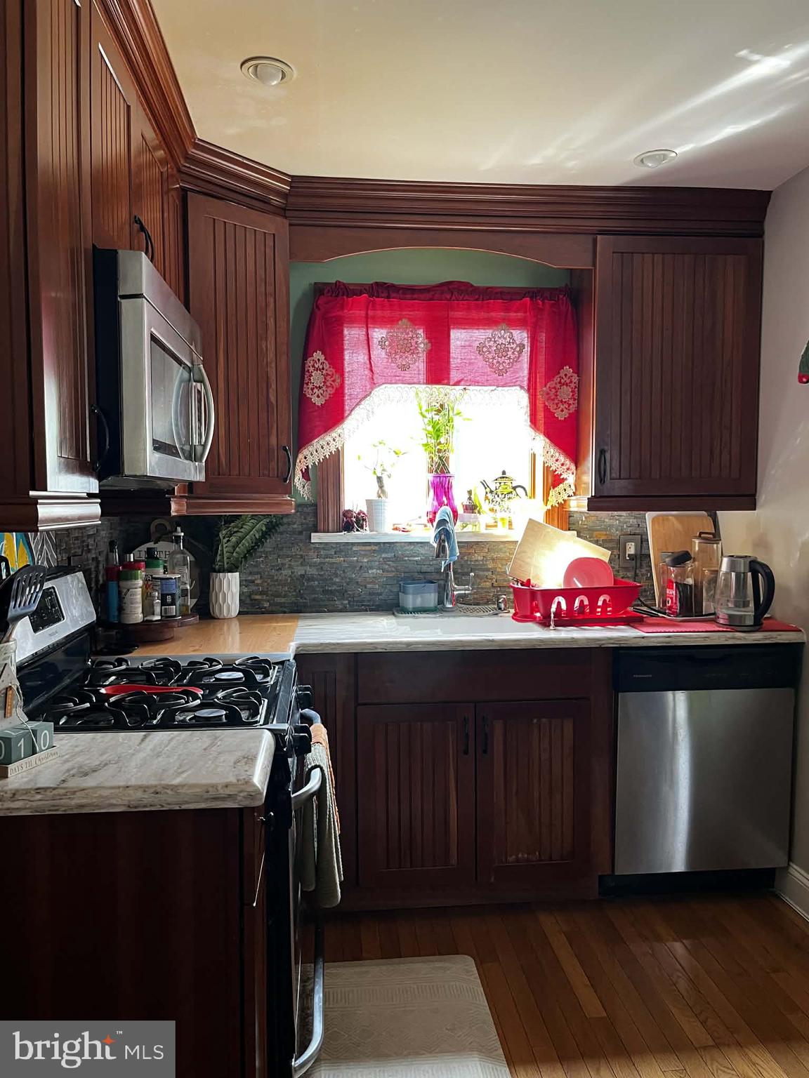 114 South Bishop Avenue Springfield, PA 19064 - Photo 3 of 9 a kitchen with stainless steel appliances a stove a sink dishwasher and cabinets with wooden floor