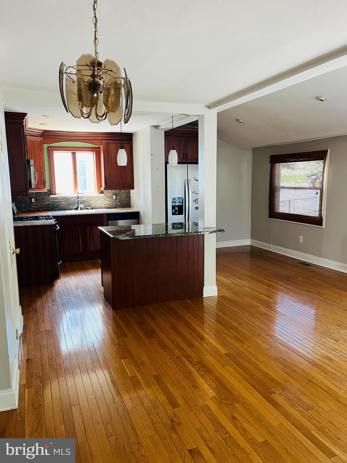 114 South Bishop Avenue Springfield, PA 19064 - Photo 3 of 20 a view of a kitchen with kitchen island wooden floors stainless steel appliances and a fireplace