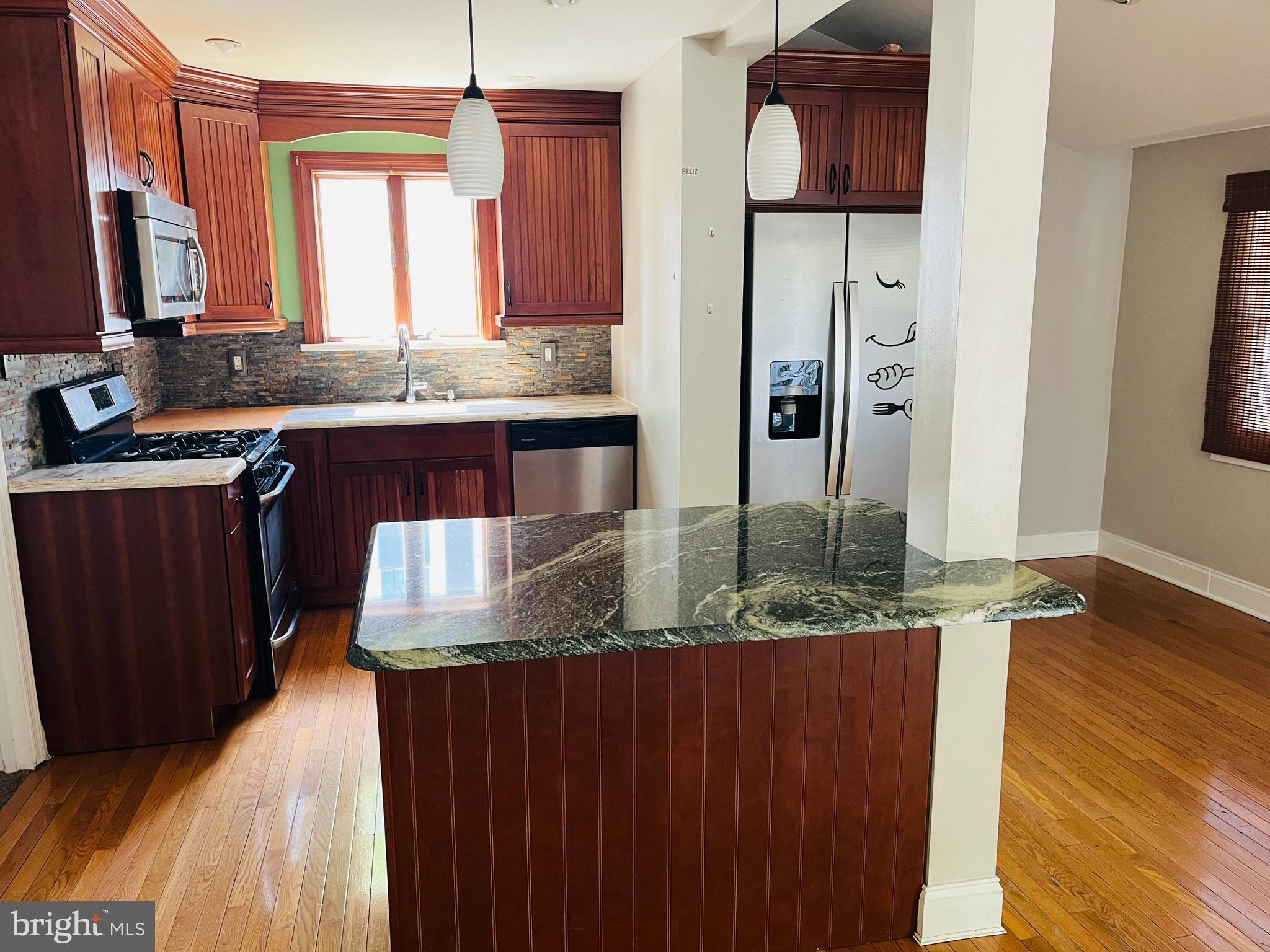 114 South Bishop Avenue Springfield, PA 19064 - Photo 4 of 20 a kitchen with granite countertop a sink and wooden cabinets