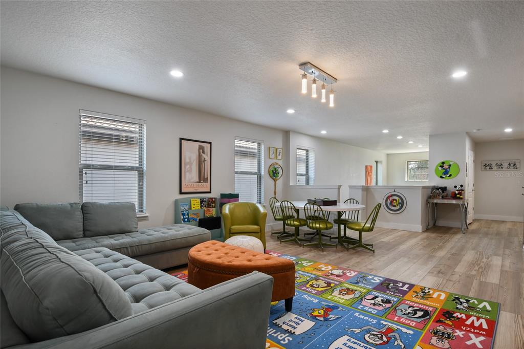 8869 Rhodes Street Kissimmee, FL 34747 - Photo 22 of 66 a living room with furniture and wooden floor