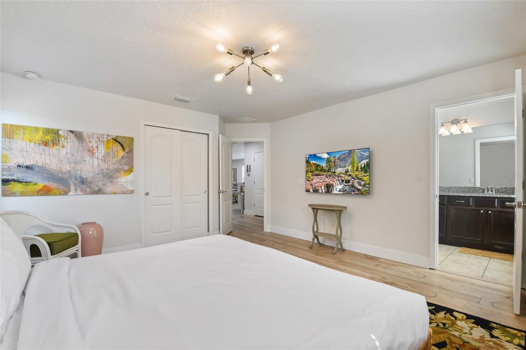 8869 Rhodes Street Kissimmee, FL 34747 - Photo 25 of 66 a bedroom with a bed and a chandelier