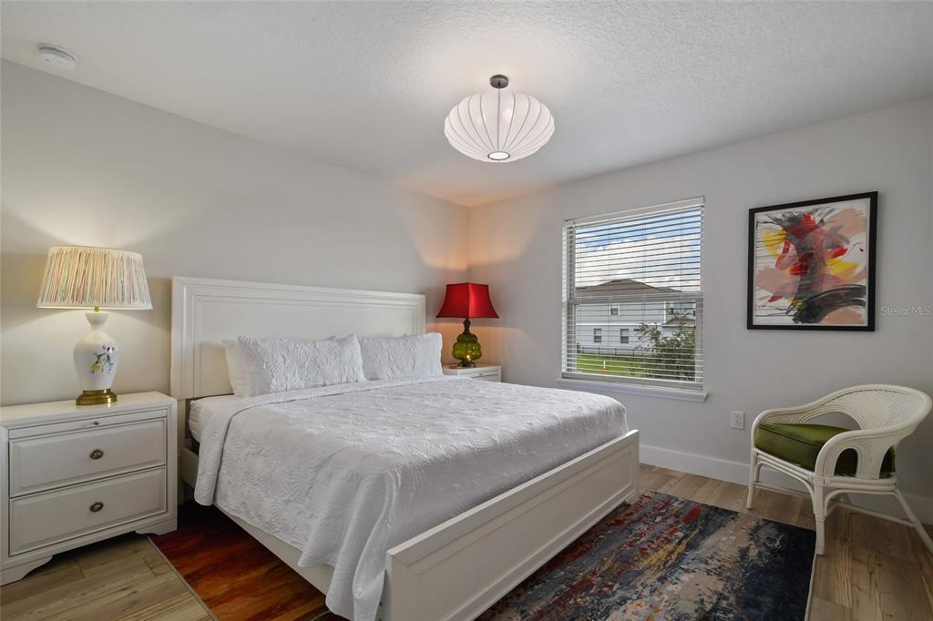 8869 Rhodes Street Kissimmee, FL 34747 - Photo 37 of 66 a bedroom with a bed and a chandelier